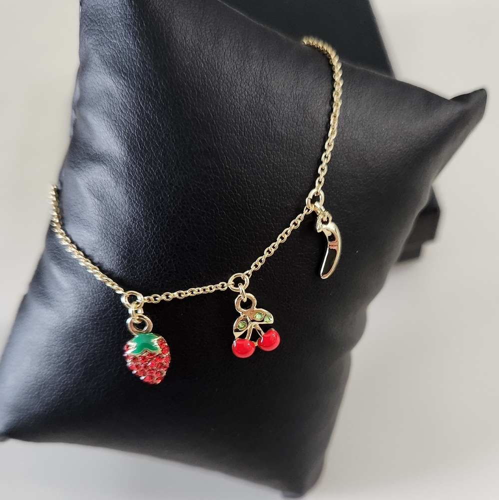Rachel Roy Gold Tone charm bracelet.. cherry, strawberry, and banana charms